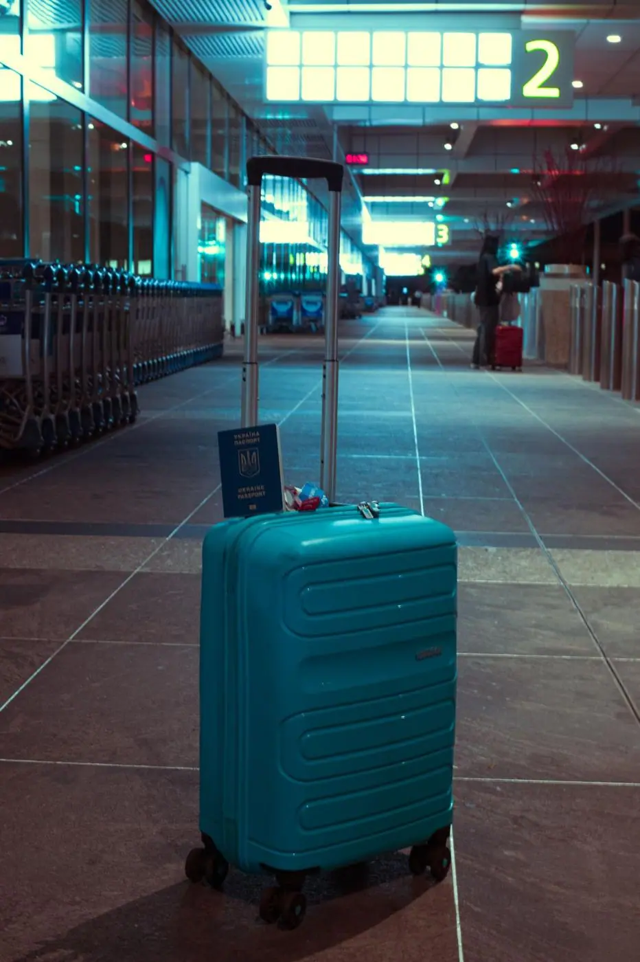 A turquoise suitcase in an airport hall